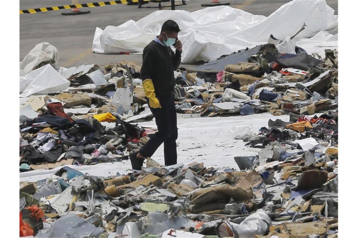 Ein Ermittler inmitten von Trümmern der Boeing 737 Max von Lion Air. Foto: Tatan Syuflana/AP/dpa