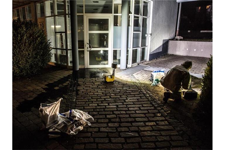 Ein Ermittler untersucht Ölspuren vor einem Gebäude in Herbrechtingen. Foto: Markus Brandhuber/Ostalb Network/dpa/Archivbild