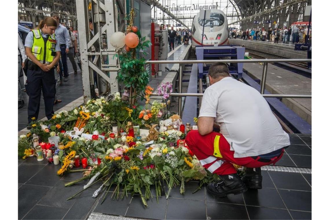 Der Verdächtige: Zuverlässig, unauffällig - psychisch krank Ein Ersthelfer, der am Tag zuvor vor Ort war, legt am Bahnsteig 7 im Frankfurter Hauptbahnhof Blumen nieder. Foto: Frank Rumpenhorst