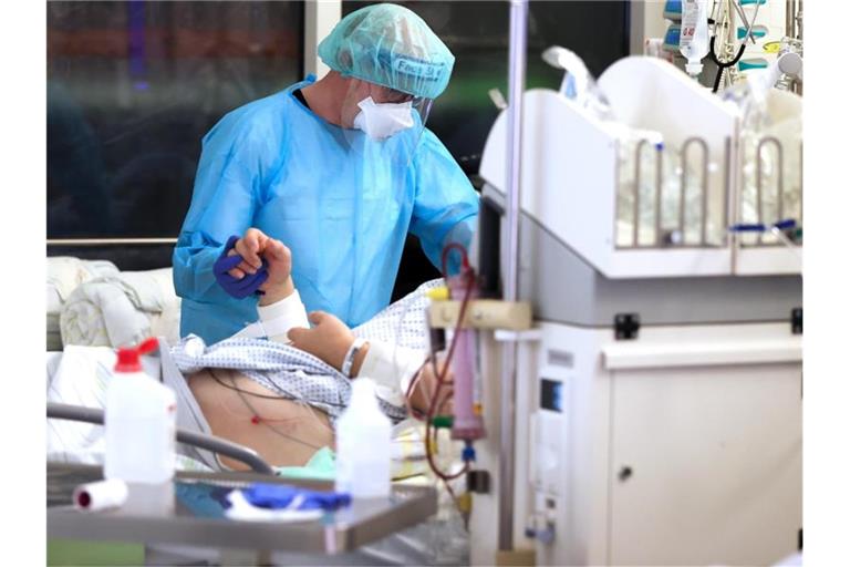 Ein Facharzt versorgt einen Covid-19-Patienten auf der Intensivstation der Leipziger Uniklinik. Foto: Jan Woitas/dpa-Zentralbild/dpa