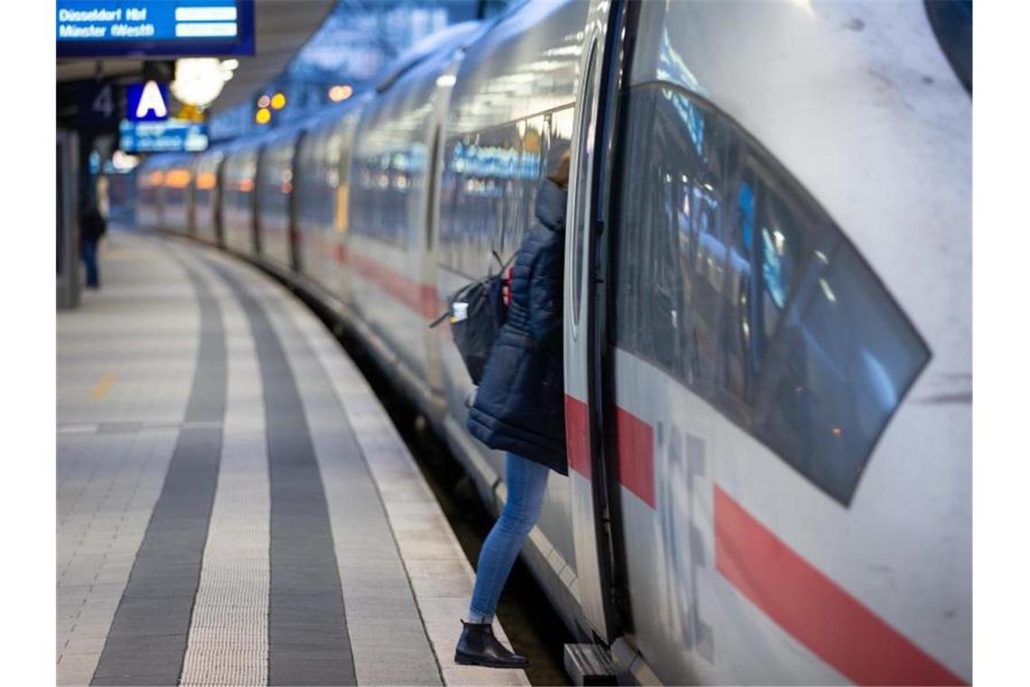 EVG warnt vor Reservierungspflicht - Bahn mit Verlust Ein Fahrgast steigt in einen Fernzug der Deutschen Bahn. Die EVG spricht sich gegen eine Reservierungspflicht in Zügen aus. Foto: Friso Gentsch/dpa