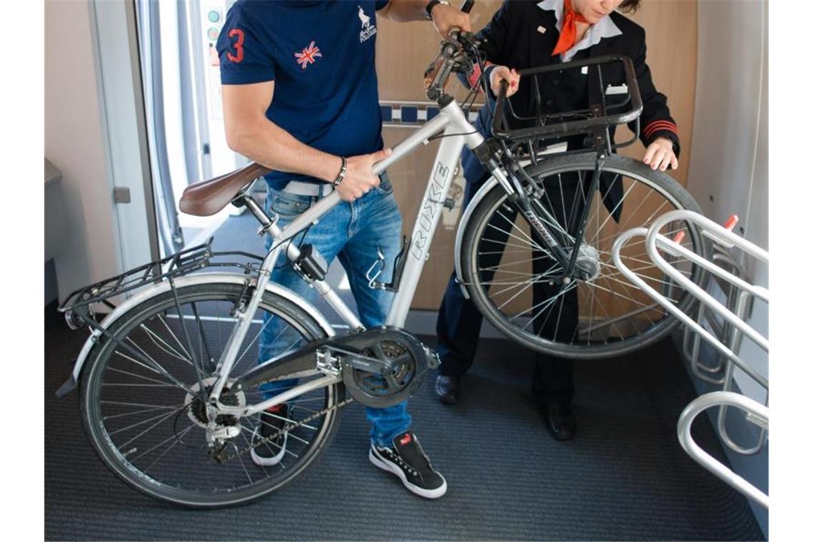 Ein Fahrgast verstaut sein Fahrrad in einem ICE 4. Die Bahn will diesen Service ausbauen. Foto: Andreas Gebert/dpa