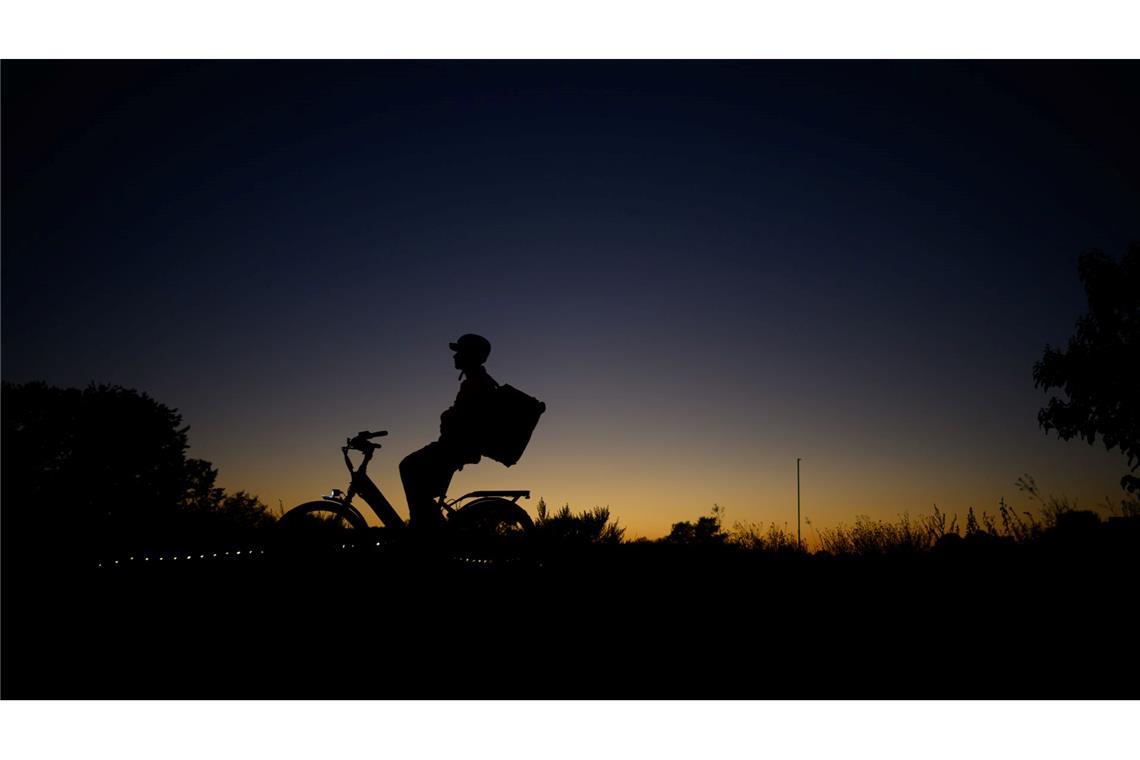 Ein Fahrradfahrer ist am Abend nach dem Sonnenuntergang auf dem Elberadweg an der Hafencity in Dresden unterwegs.