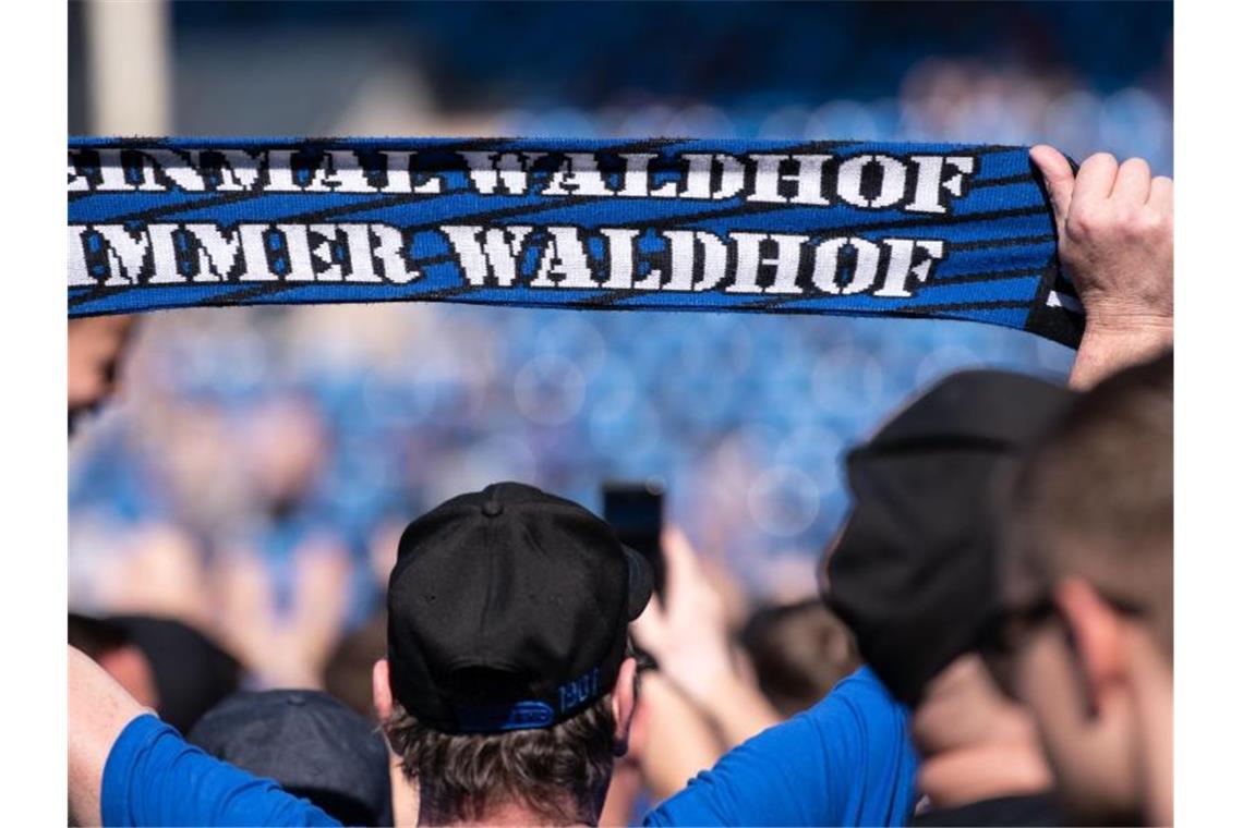 Ein Fan hält nach dem Spiel ein Schal mit der Aufschrift „Einmal Waldhof immer Waldhof“ in die Höhe. Foto: Silas Stein/Archiv