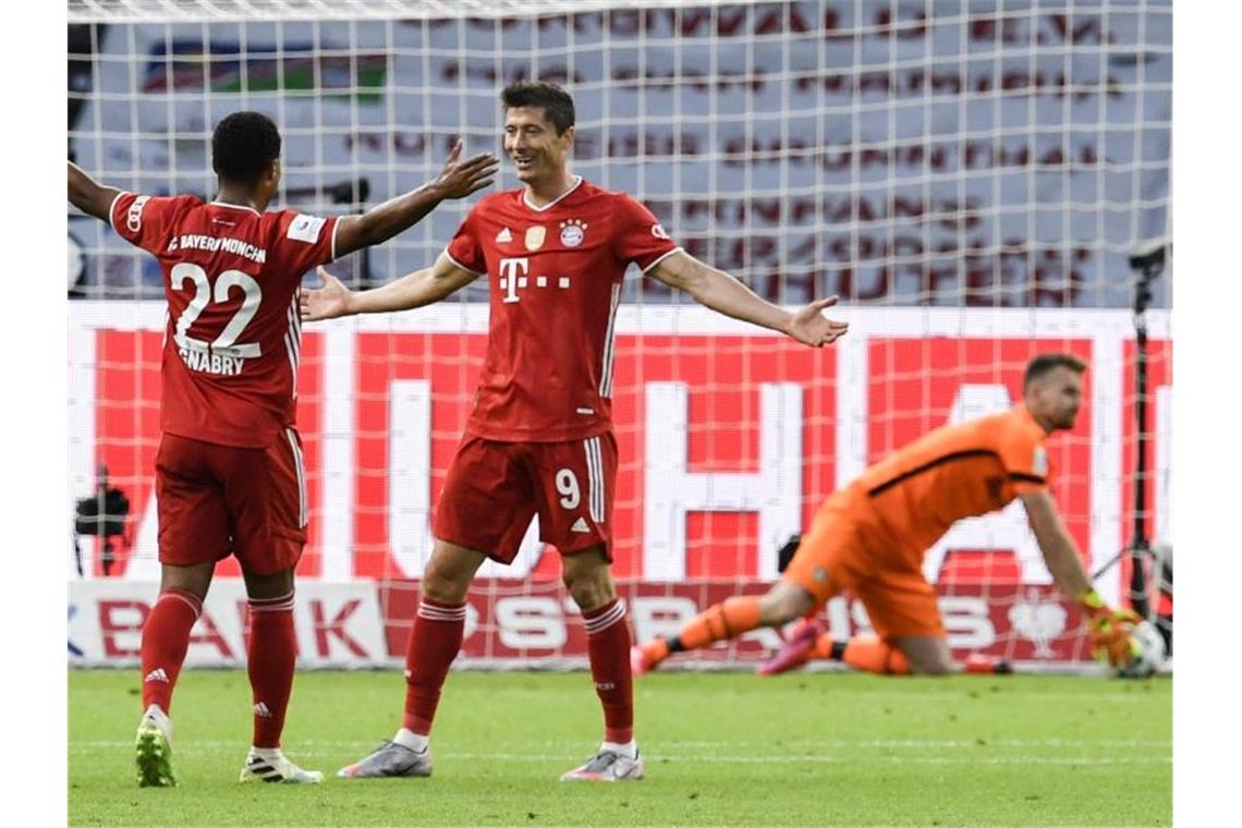 Ein Fehler von Bayer-Keeper Lukas Hradecky ebnete Bayern den Weg zum 3:0 durch Robert Lewandowski (M). Foto: John Macdougall/AFP/POOL/dpa