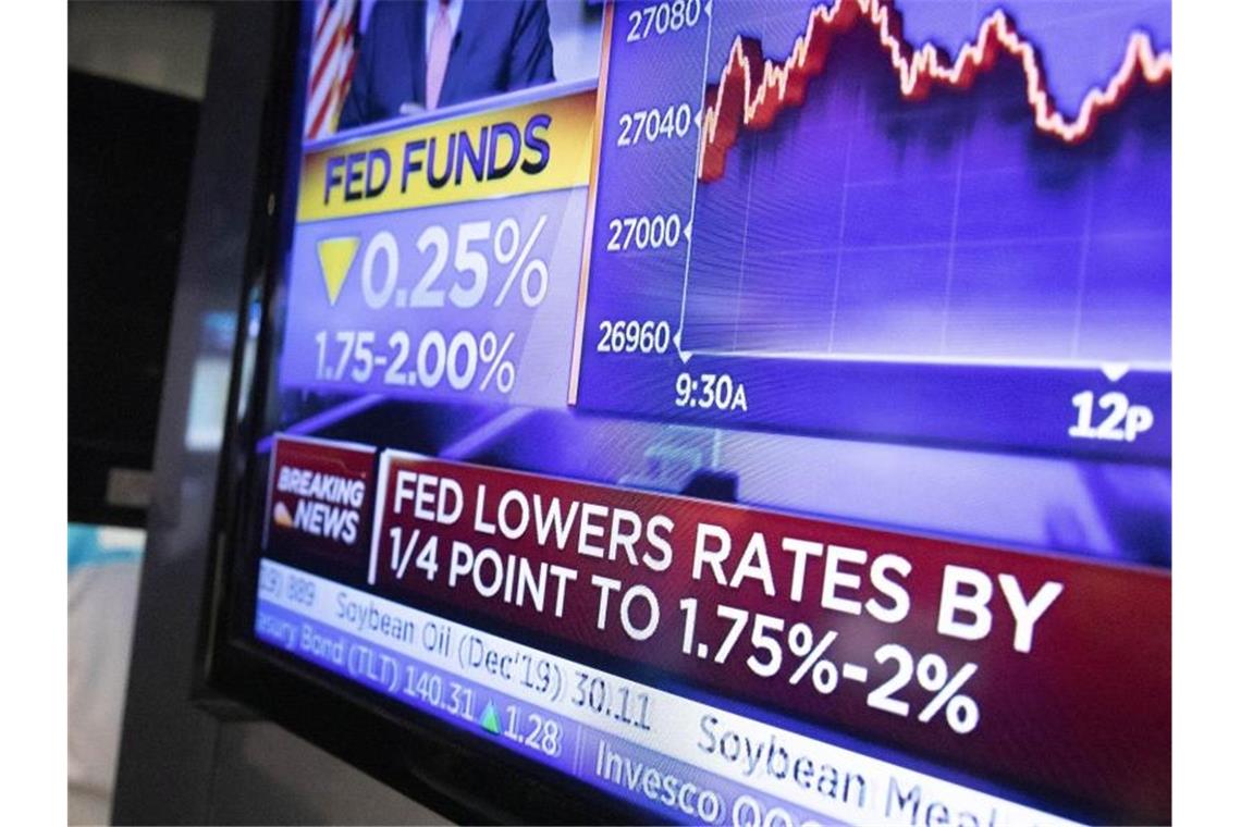 Konjunkturrisiko Trump: Leitzinssenkung soll es richten Ein Fernseher an der New Yorker Börse überträgt die Nachricht, dass die US-Notenbank ihre Zinsänderung bekannt gegeben hat. Foto: Mark Lennihan/AP