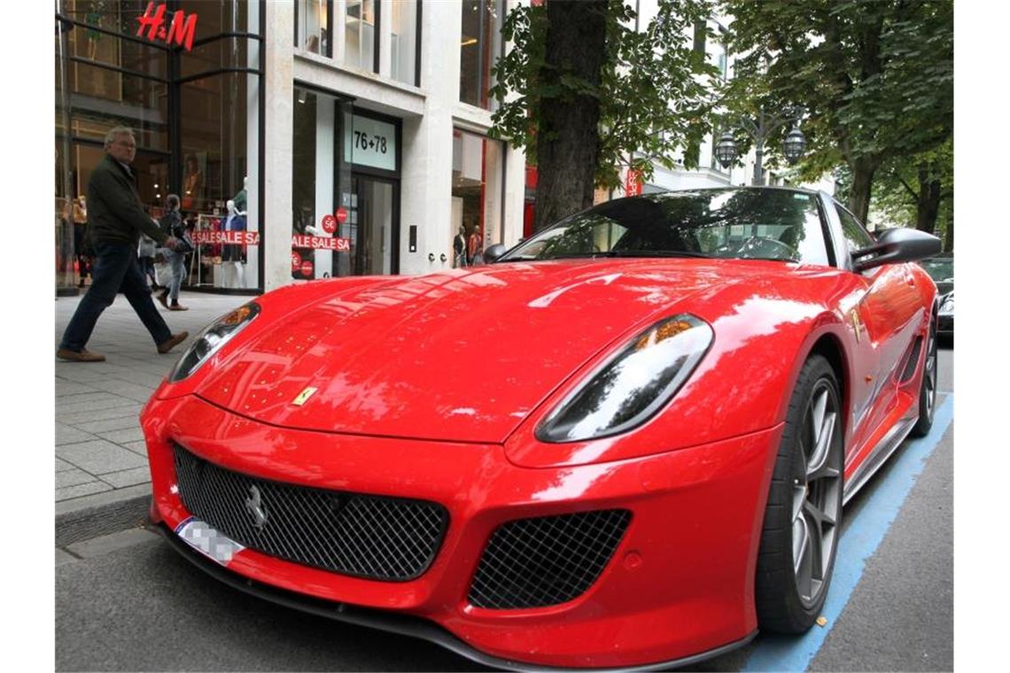 Ein Ferrari parkt auf der Königsallee in Düsseldorf, die als Laufsteg der Reichen und Schönen gilt. Foto: Martin Gerten