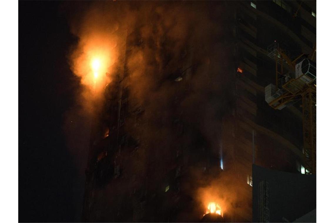 Ein Feuer brennt an der Seite des Hochhauses in Schardscha. Foto: Jon Gambrell/AP/dpa