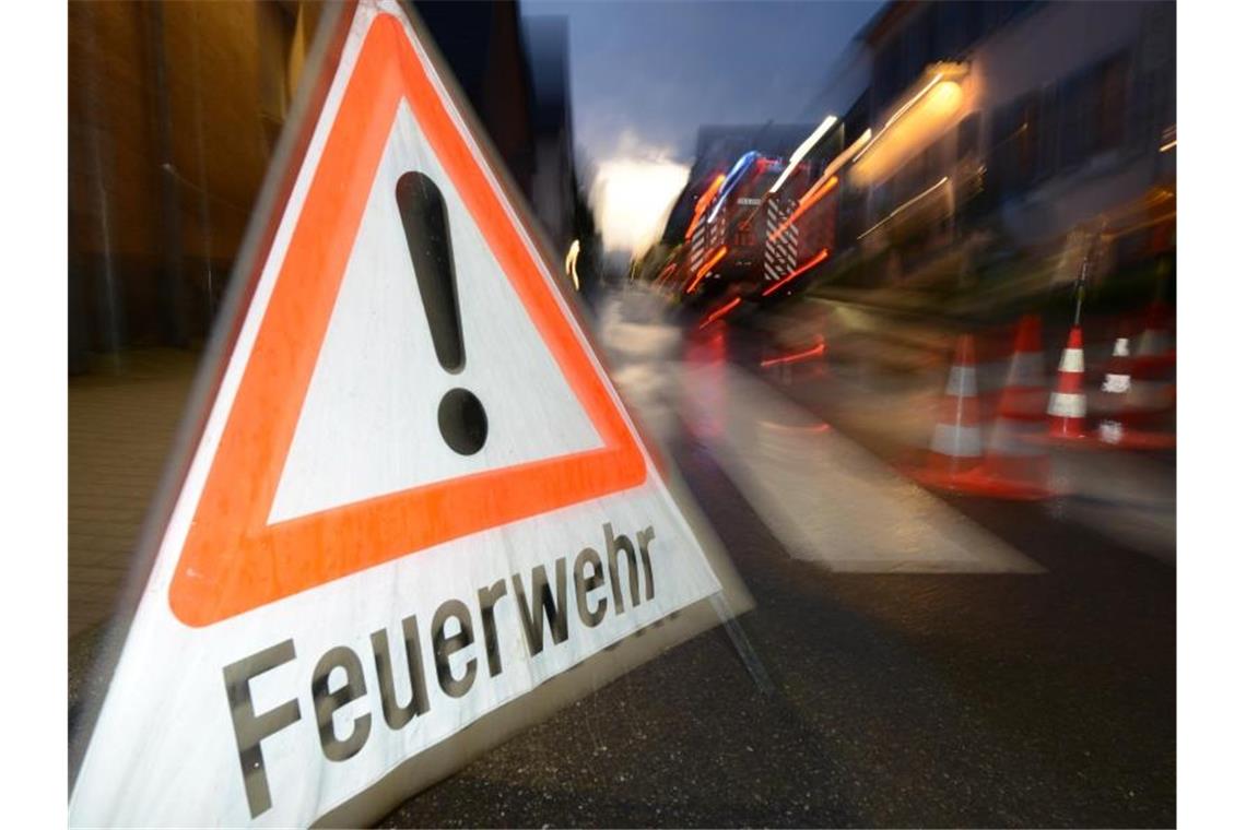 Zwei junge Mädchen verschanzen sich auf einem Dach Ein Feuerwehr-Warnschild. Foto: Patrick Seeger/Archiv
