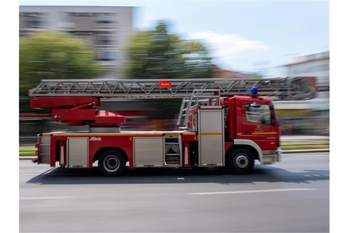 Ein Feuerwehrauto fährt mit Blaulicht zu einem Einsatz. Foto: Monika Skolimowska/zb/dpa/Archivbild