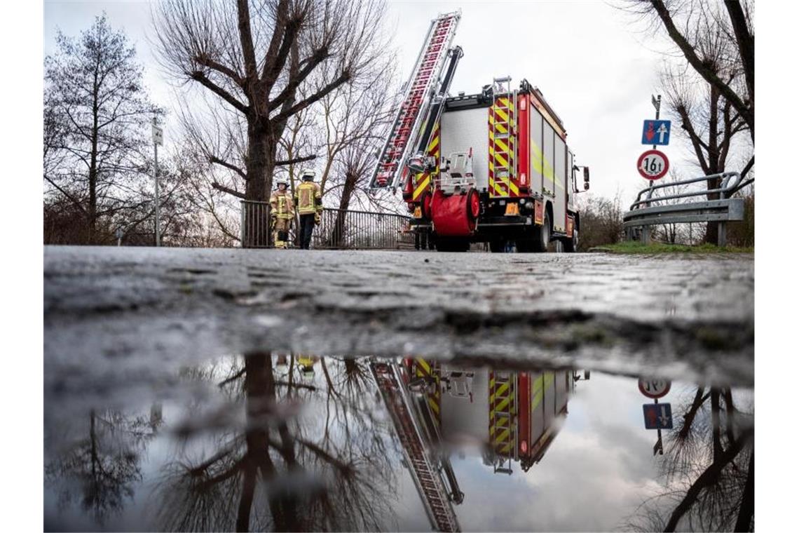 Ein Feuerwehrauto steht auf einer Brücke, die über den Fluss Hönne führt. Foto: Fabian Strauch/dpa