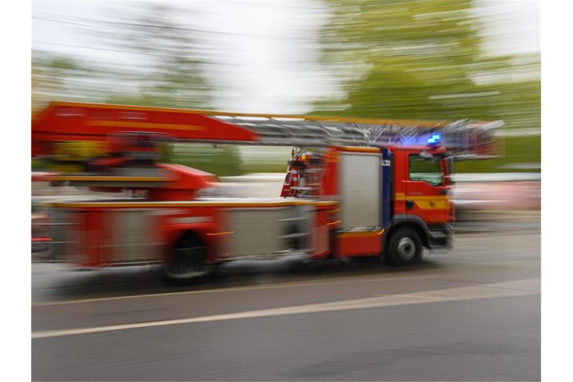 Ein Feuerwehrfahrzeug mit Drehleiter fährt zu einem Einsatz. Foto: Robert Michael/dpa-Zentralbild/ZB/Symbolbild