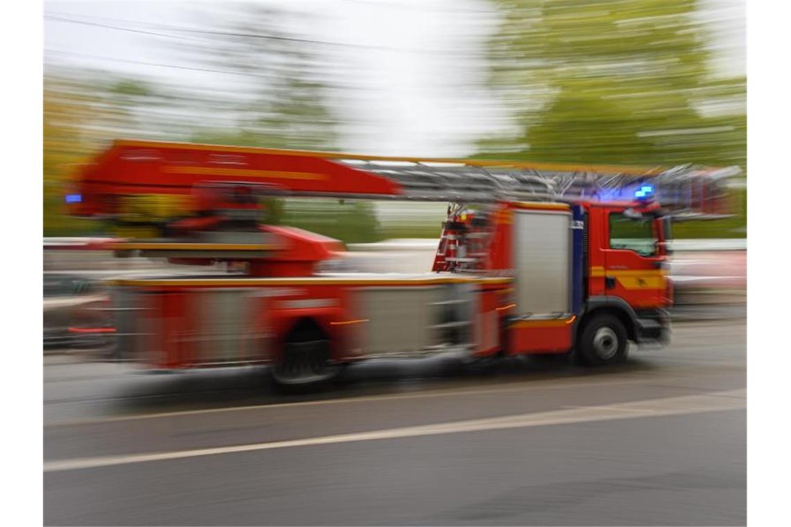 Ein Feuerwehrfahrzeug mit Drehleiter fährt zu einem Einsatz. Foto: Robert Michael/dpa-Zentralbild/ZB/Symbolbild