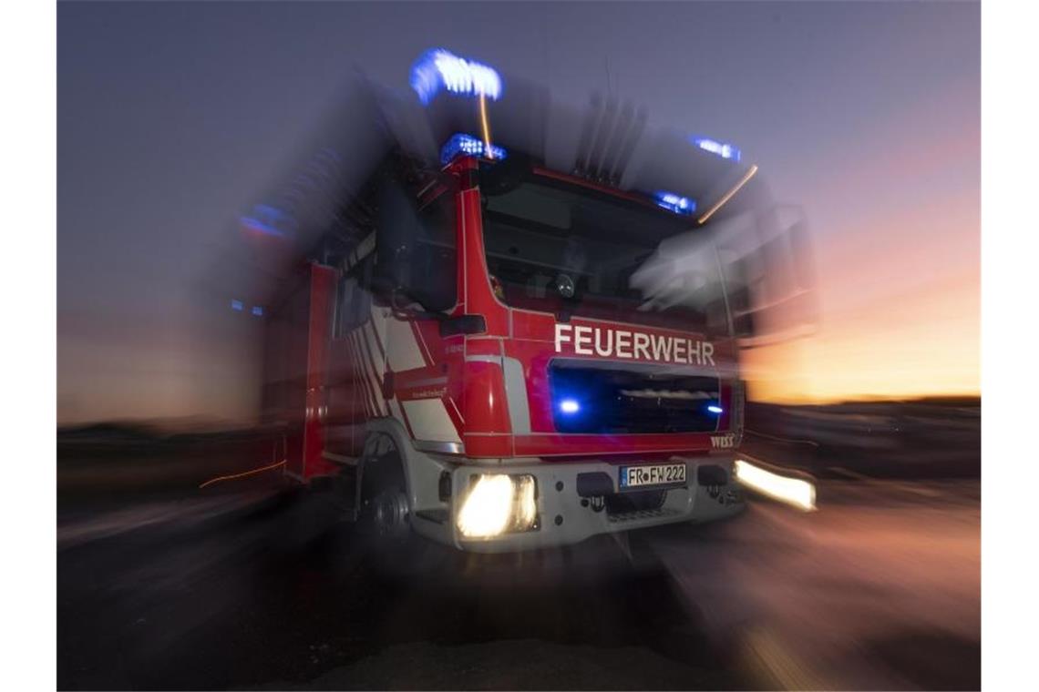 Ein Feuerwehrfahrzeug mit eingeschaltetem Blaulicht. Foto: Patrick Seeger/dpa/Symbolbild