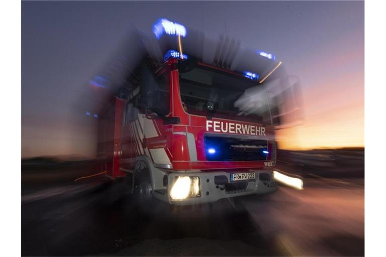 Ein Feuerwehrfahrzeug mit eingeschaltetem Blaulicht. Foto: Patrick Seeger/dpa/Symbolbild