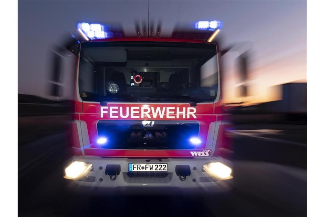 Brand in Mehrfamilienhaus: 65-Jähriger in Klinik gebracht Ein Feuerwehrfahrzeug steht mit eingeschaltetem Blaulicht im Sonnenuntergang auf einer Straße. Foto: Patrick Seeger/dpa/Archivbild