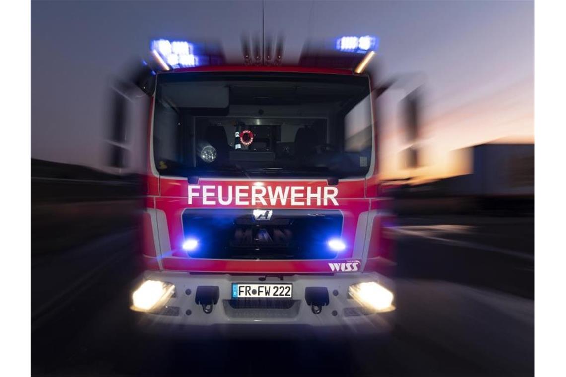 Scheunenbrand verursacht hohen Schaden Ein Feuerwehrfahrzeug steht mit eingeschaltetem Blaulicht auf einer Straße. Foto: Patrick Seeger/dpa/Symbolbild