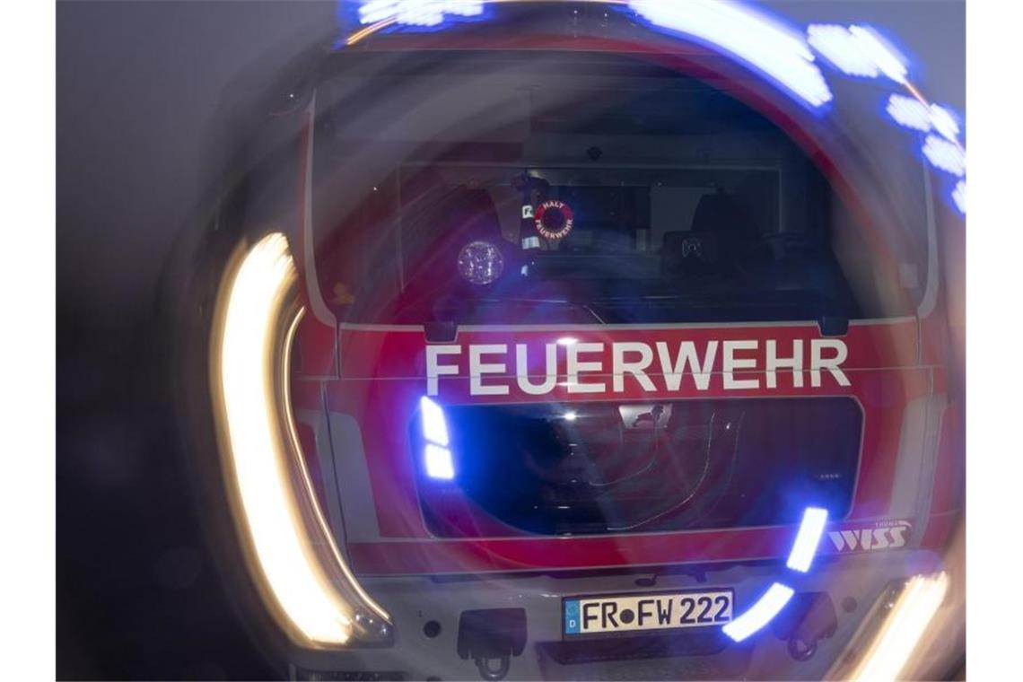 Zwei Verletzte bei Wohnungsbrand in Stuttgart Ein Feuerwehrfahrzeug steht mit eingeschaltetem Blaulicht im Sonnenuntergang auf einer Straße. Foto: Patrick Seeger/dpa/Symbolbild