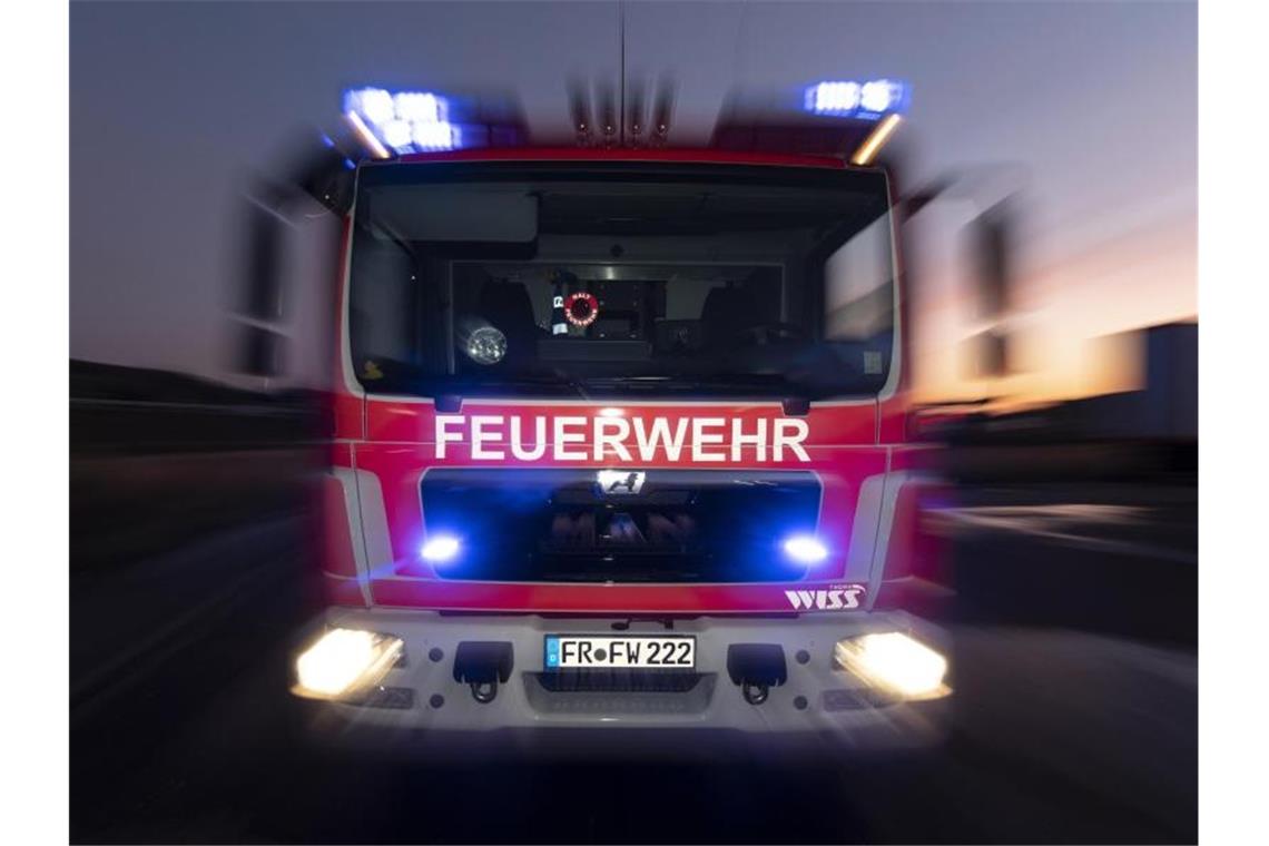Brand in Essinger Baumarkt: Zehn Leichtverletzte Ein Feuerwehrfahrzeug steht mit eingeschaltetem Blaulicht im Sonnenuntergang auf einer Straße. Foto: Patrick Seeger/dpa/Archivbild