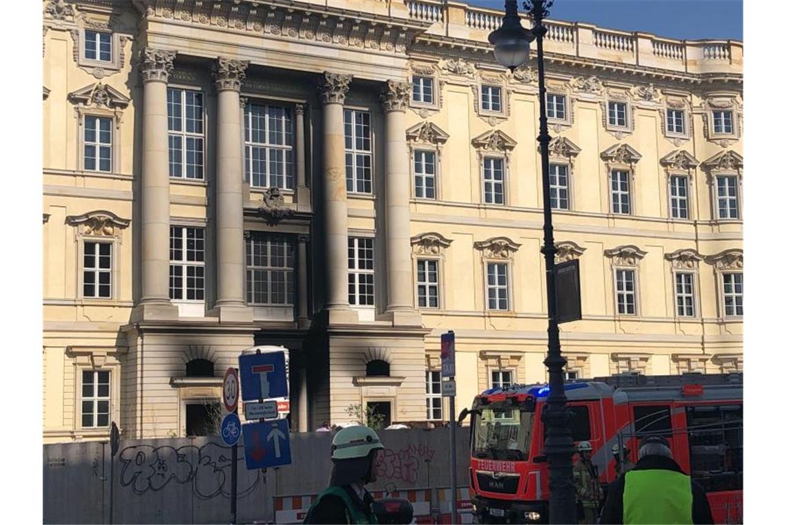 Ein Feuerwehrfahrzeug steht vor dem Berliner Humboldt Forum. Teile der Fassade sind schwarz vom Ruß. Foto: Christophe Gateau/dpa
