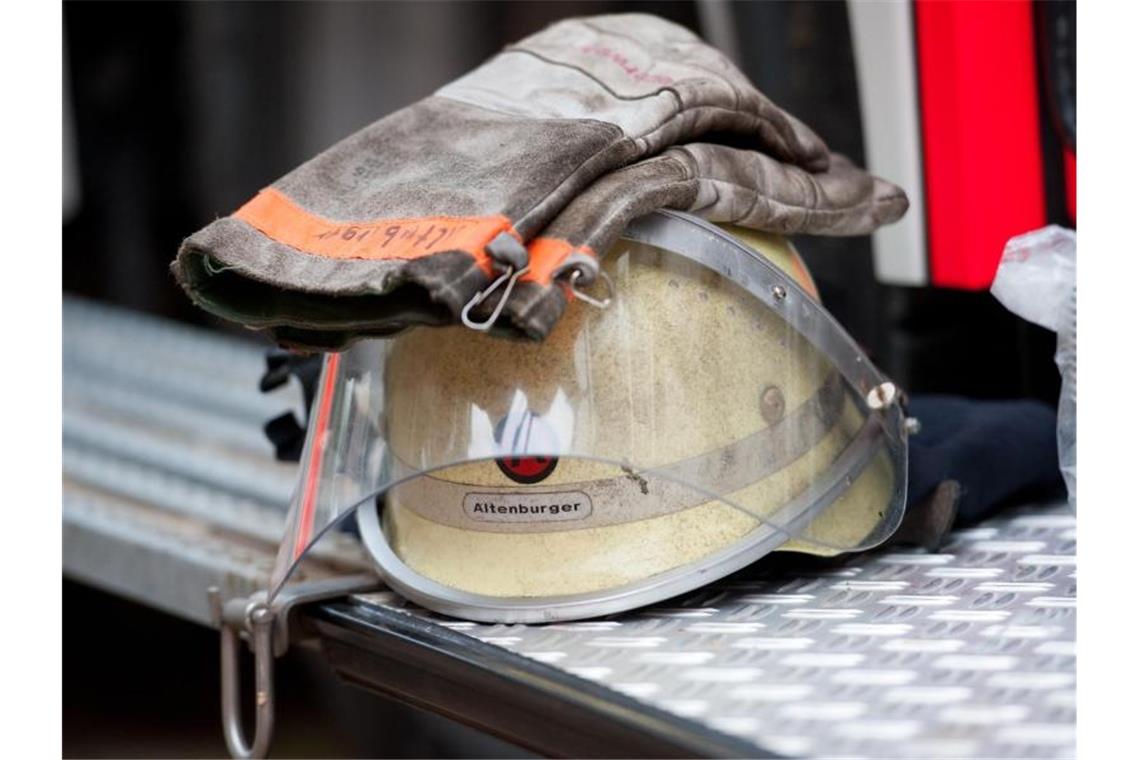 Ein Feuerwehrhelm liegt an einem Einsatzfahrzeug. Foto: picture alliance/dpa/Archivbild