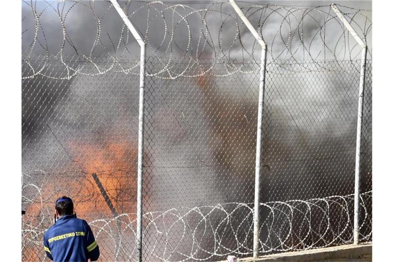 Ein Feuerwehrmann beim Kampf gegen die Flammen. Im Registriercamp von Vathy auf der griechischen Insel Samos ist am Mittwoch ein großer Brand ausgebrochen. Foto: Michael Svarnias/AP/dpa