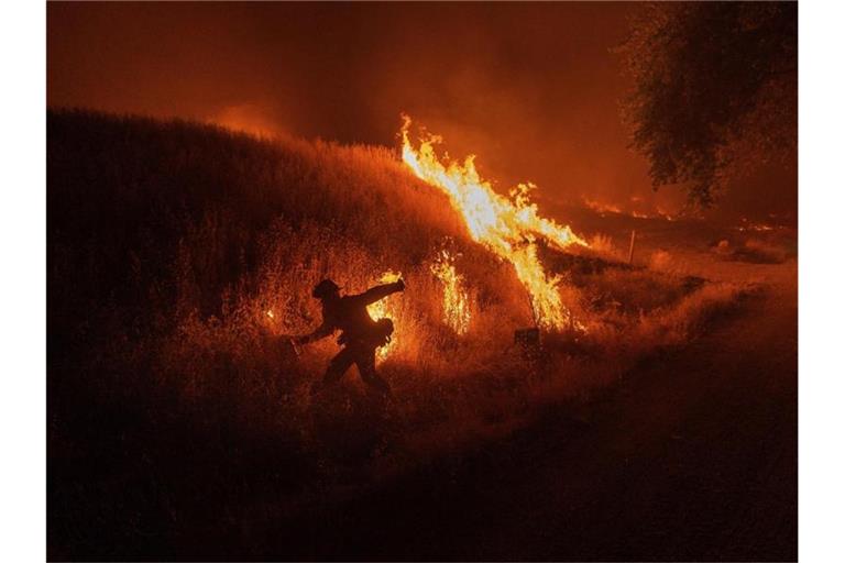 Ein Feuerwehrmann entzündet kontrollierte Gegenfeuer, um die Ausbreitung des Waldbrands zu verhindern. Foto: Noah Berger/FR34727 AP/dpa