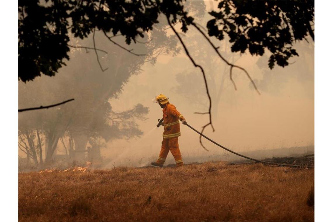 Zwei weitere Tote im Kampf gegen Australiens Buschbrände Ein Feuerwehrmann in Australien beim Löschen eines Brand. Bisher konnten die Feuer nicht unter Kontrolle gebracht werden. Foto: Kelly Barnes/AAP/dpa