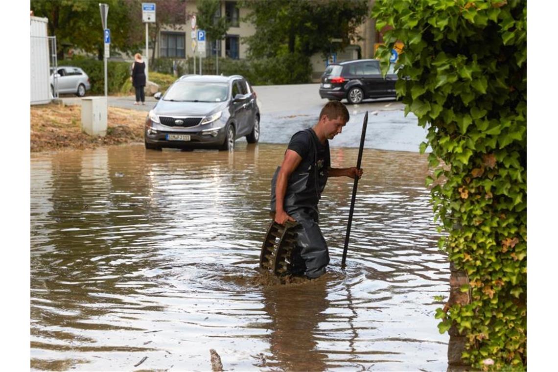 Unwetter ziehen über Teile Deutschlands Ein Feuerwehrmann ist nach dem Starkregen im Rheintal im Einsatz. Foto: Thomas Frey