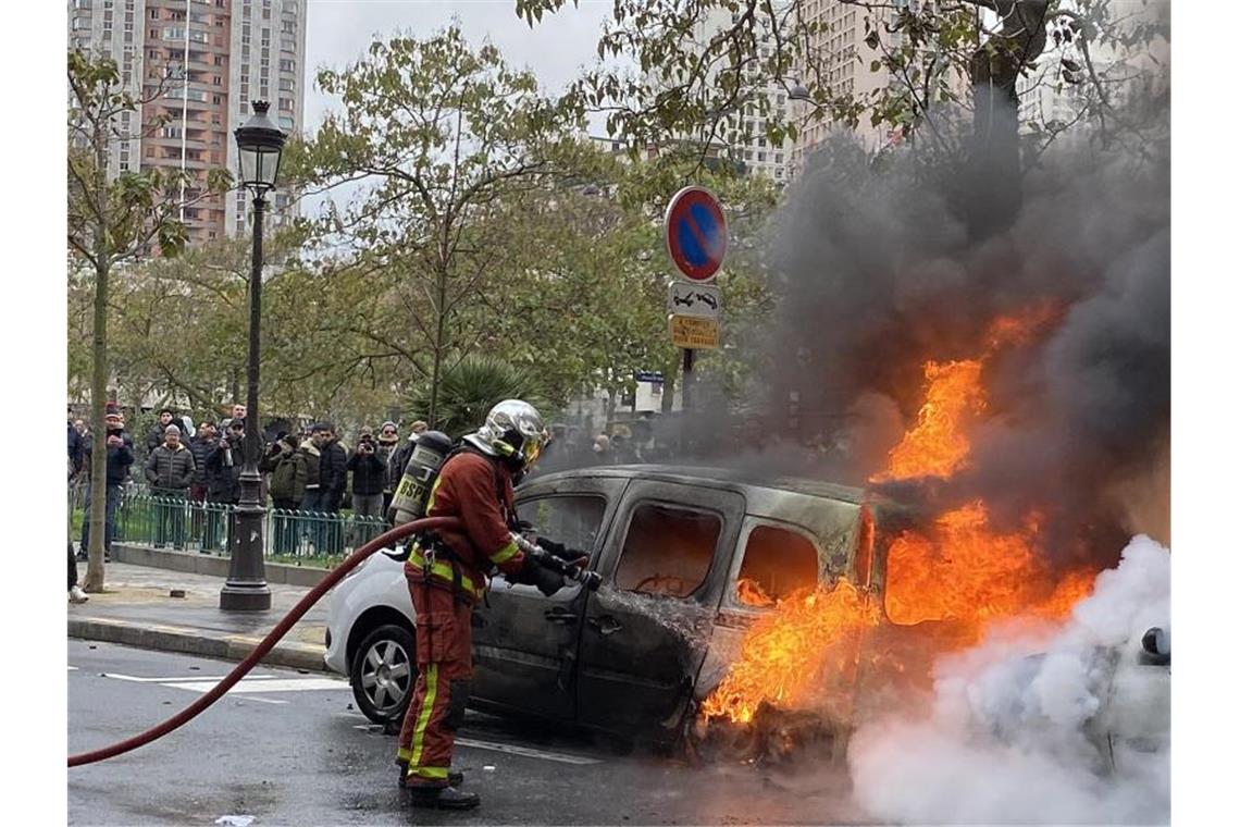 Rückkehr der Gewalt zum Jahrestag der „Gelbwesten“-Proteste Ein Feuerwehrmann löscht in Paris ein von „Gelbwesten“ in Brand gesetztes Auto. Foto: Kong Fan/XinHua/dpa