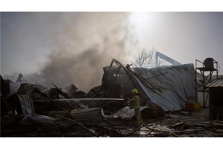 Ein Feuerwehrmann löscht in Zentralisrael ein Feuer an der Stelle, an der eine iranische Rakete eingeschlagen ist.