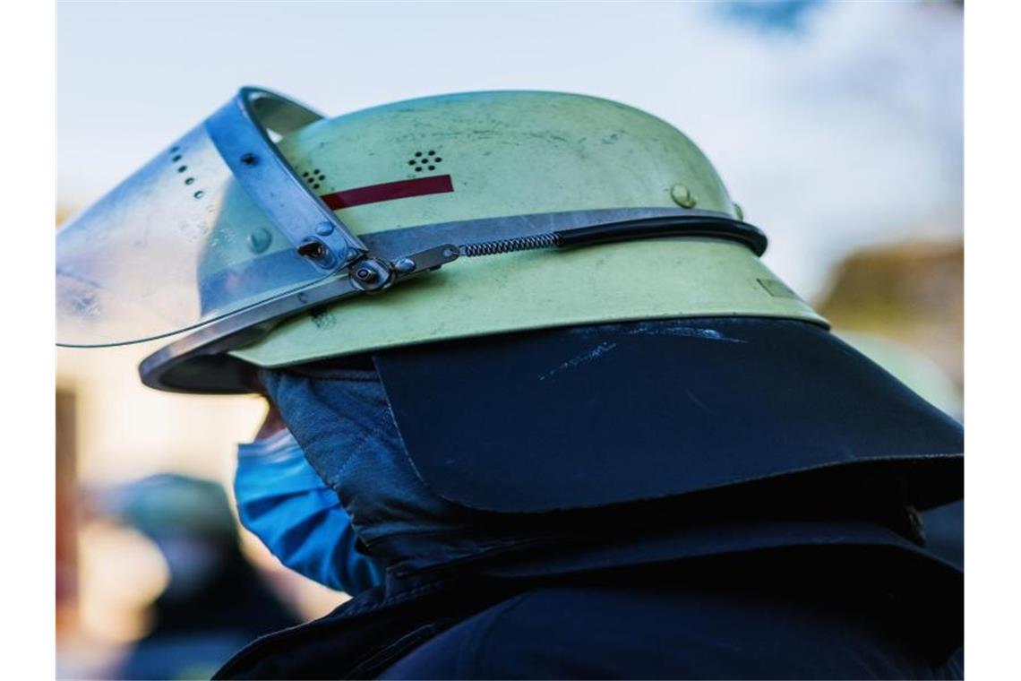 Ein Feuerwehrmann mit Helm und Maske. Foto: Philipp von Ditfurth/dpa/Symbolbild