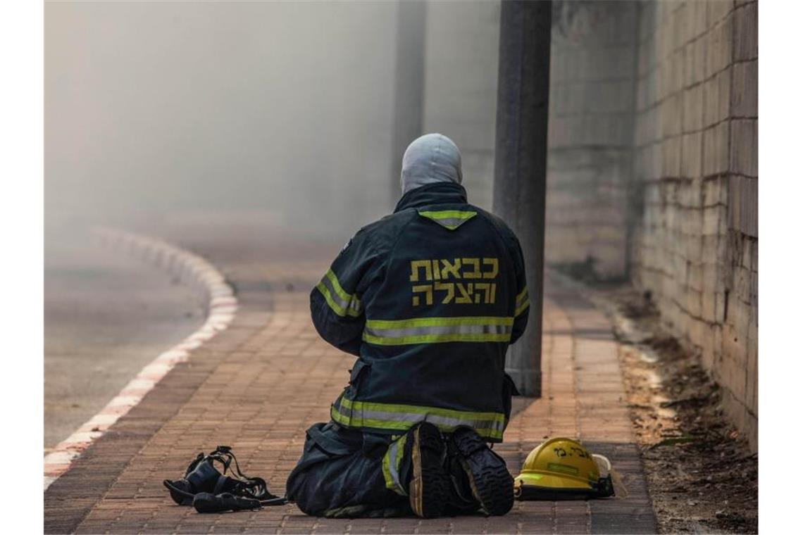 Ein Feuerwehrmann ruht sich beim Einsatz aus. Foto: Ilia Yefimovich/dpa