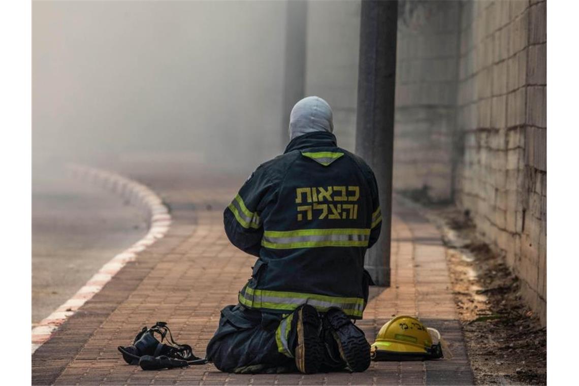 Israel tötet Dschihad-Militärchef - Beschuss aus Gaza Ein Feuerwehrmann ruht sich beim Einsatz aus. Foto: Ilia Yefimovich/dpa