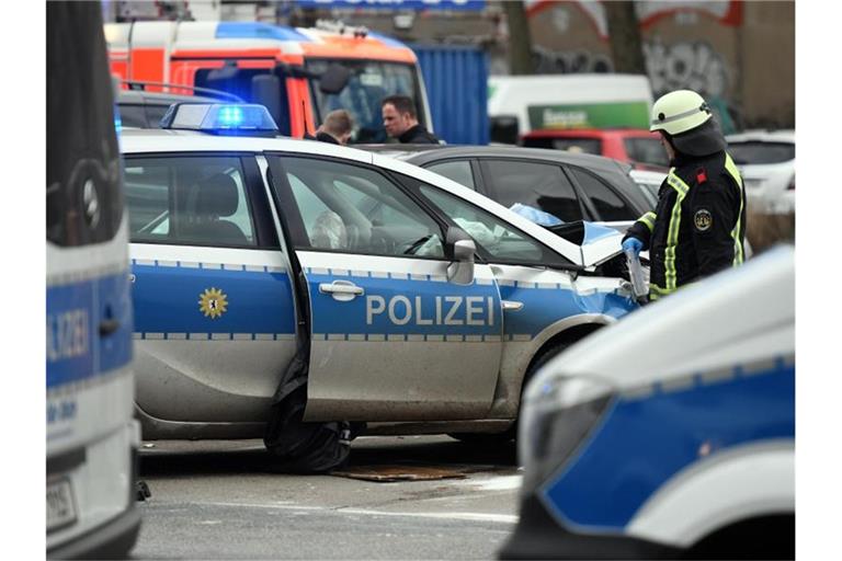 Ein Feuerwehrmann steht nach dem Unfall 2018 an dem beschädigten Polizeiauto. Foto: Maurizio Gambarini/dpa