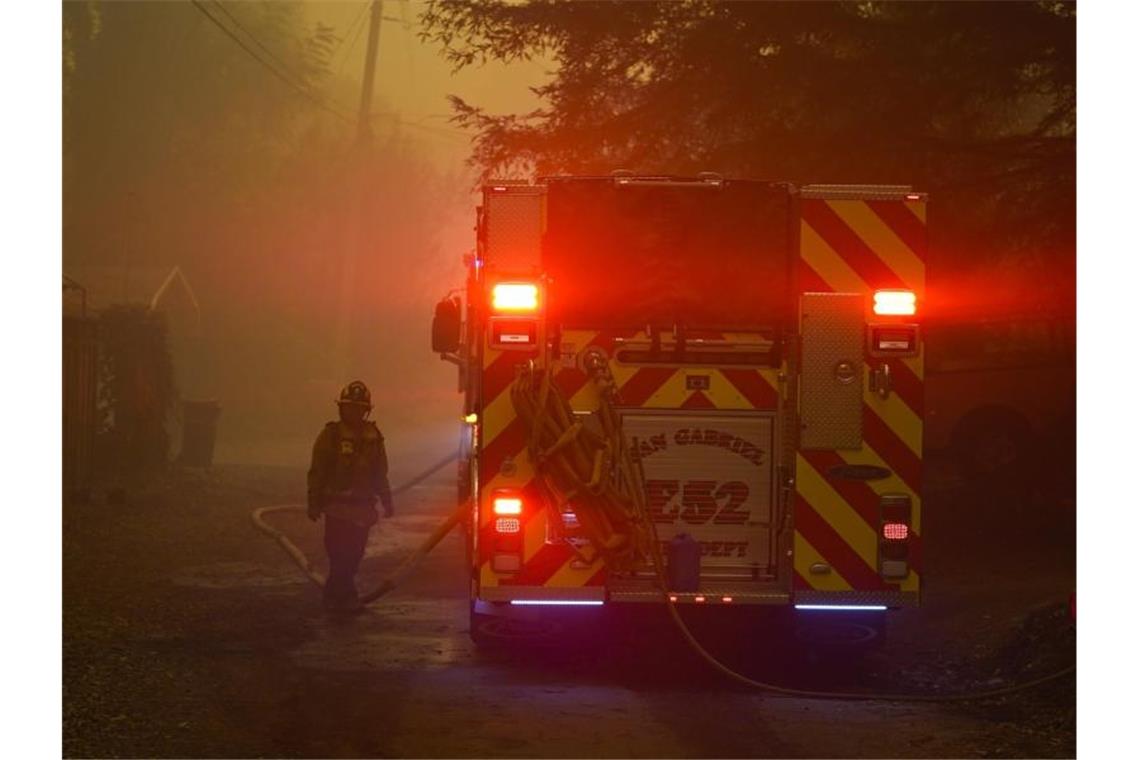 Ein Feuerwehrmann steht neben einem Einsatzwagen. Kalifornien kämpft um die Eindämmung riesiger Waldbrände und hat nun auch Hilfe aus dem In- und Ausland angefordert. Foto: Marcio Jose Sanchez/AP/dpa