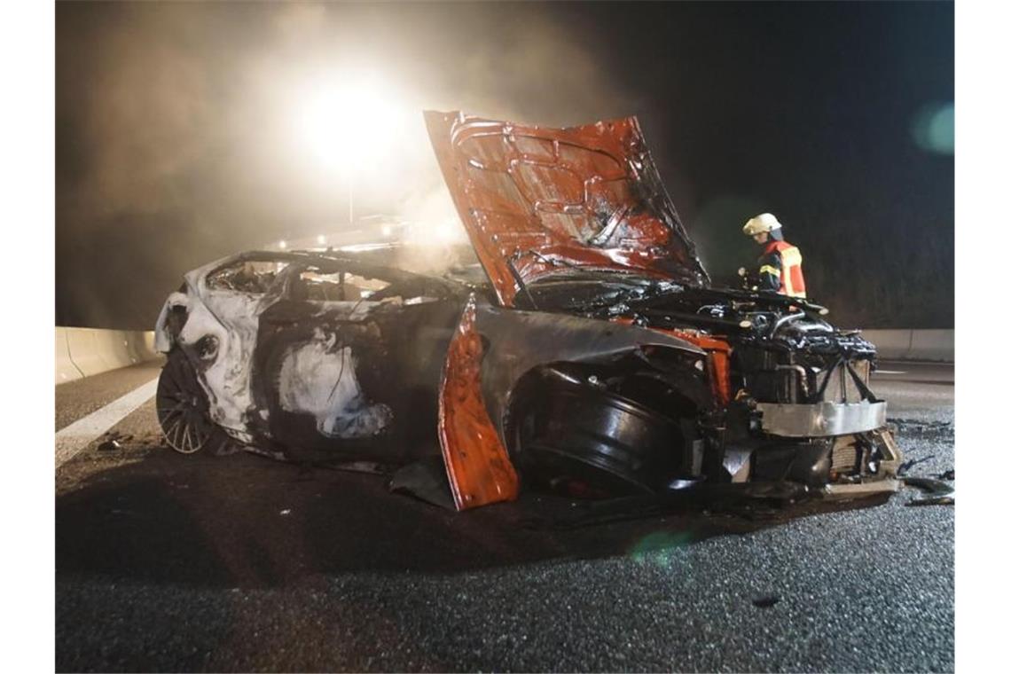 Ein Feuerwehrmann steht vor einem ausgebrannten Autowrack auf der Autobahn 81. Foto: Dettenmeyer/SDMG/dpa/Archivbild