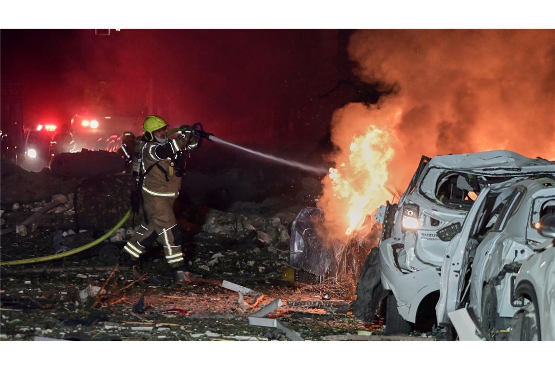 Ein Feuerwehrmann versucht, ein brennendes Auto zu löschen.