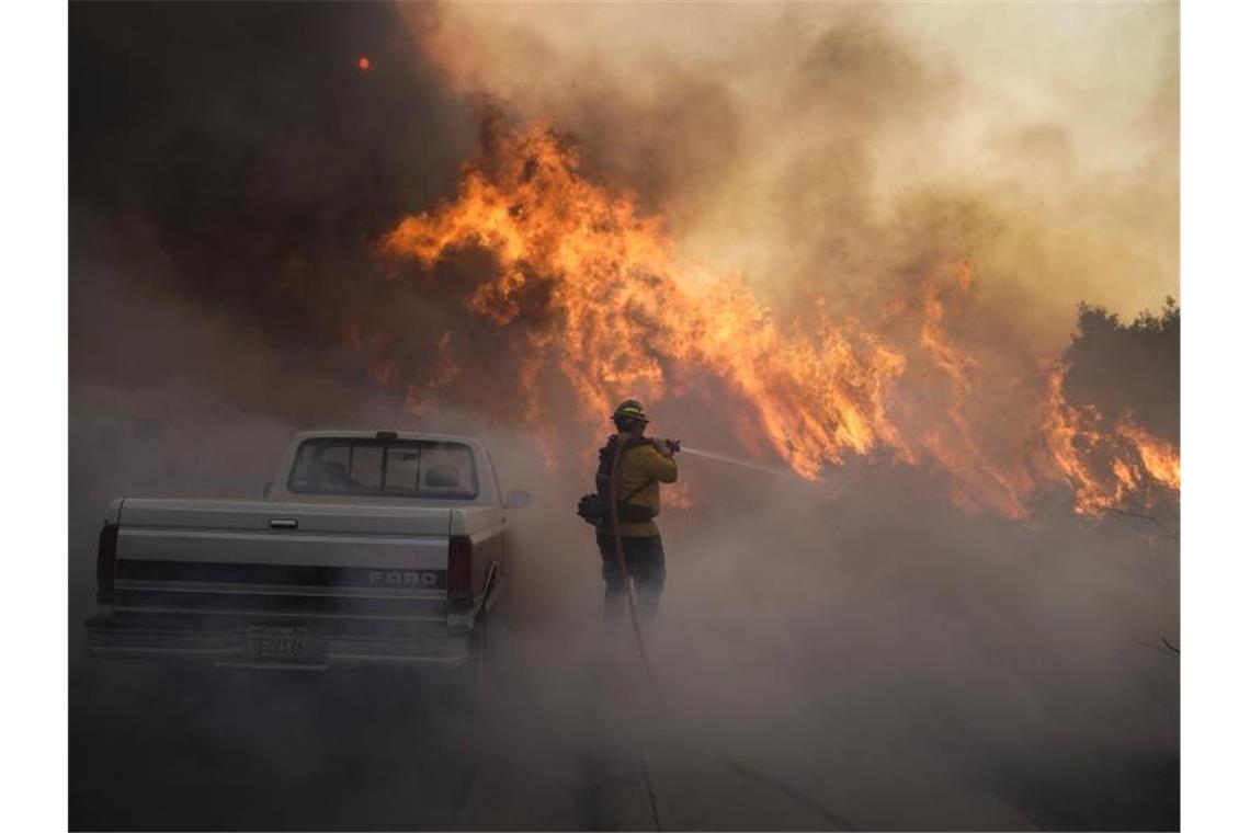 Feuer in Südkalifornien schlagen Zehntausende in die Flucht Ein Feuerwehrmann versucht, gegen die Flammen anzukämpfen. Foto: Jae C. Hong/AP/dpa