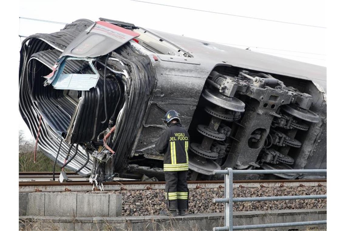 Bei Tempo 290: Schweres Zugunglück in Italien Ein Feuerwehrmann vor einem entgleisten Zugwaggon. Mehrere Waggons sollen sich überschlagen haben. Foto: Antonio Calanni/AP/dpa