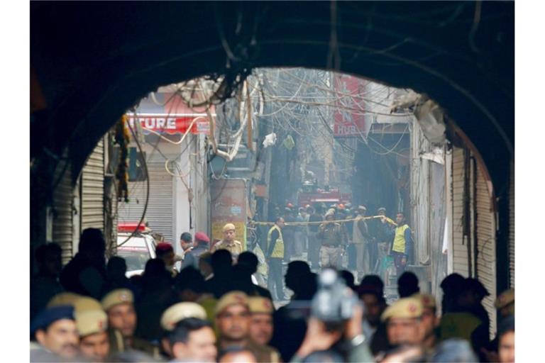 Ein Feuerwehrwagen steht in einer engen Gasse vor dem Unglücksort in Neu Delhi. Foto: Manish Swarup/AP/dpa