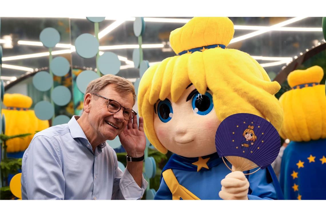 Ein Flirt auf der Expo: Außenminister Wadephul und Maskottchen "Europe-Chan" kommen sich im japanischen Osaka im Europa Pavillon näher.