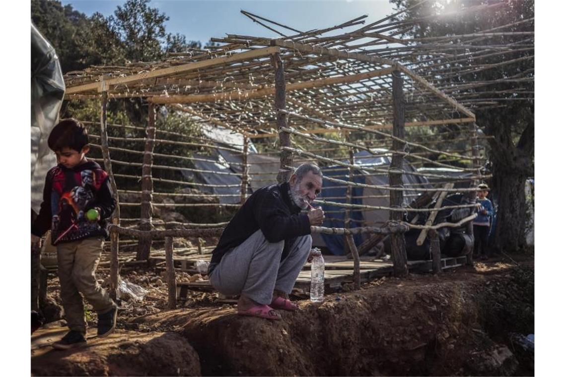 Nur wenige schutzbedürftige Flüchtlinge finden neue Heimat Ein Flüchtling putzt sich vor dem Gerüst seiner einfachen Hütte im Flüchtlingslager auf der griechischen Insel Samos die Zähne. Foto: Angelos Tzortzinis/dpa