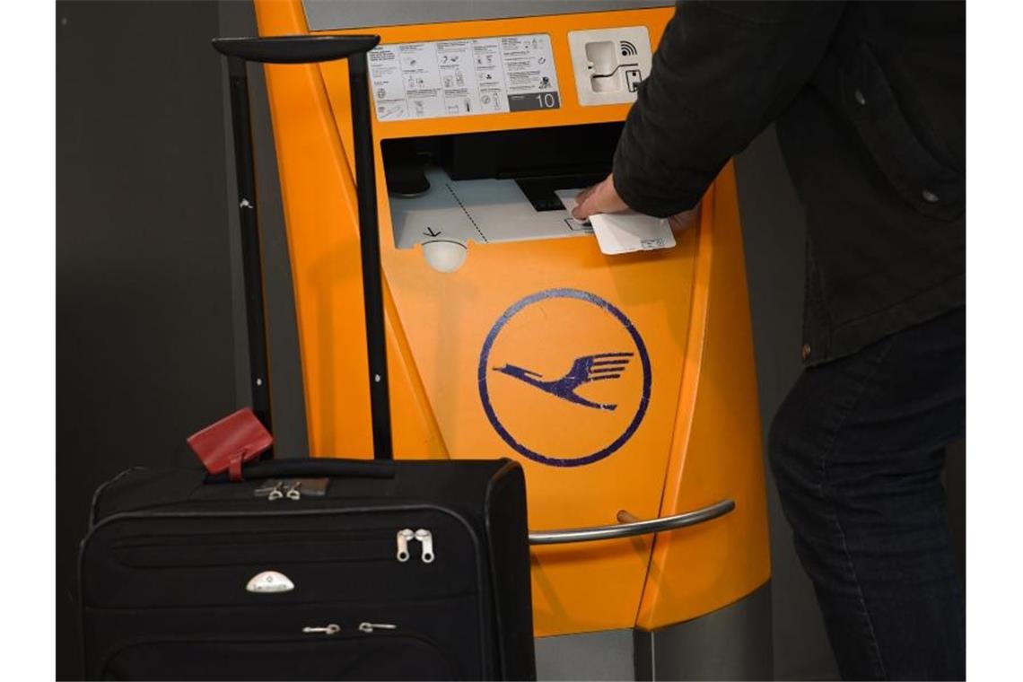 Ein Flugreisender scannt am Flughafen Frankfurt am Main sein Ticket an einem Check-in-Terminal der Lufthansa. Foto: picture alliance / Arne Dedert/dpa