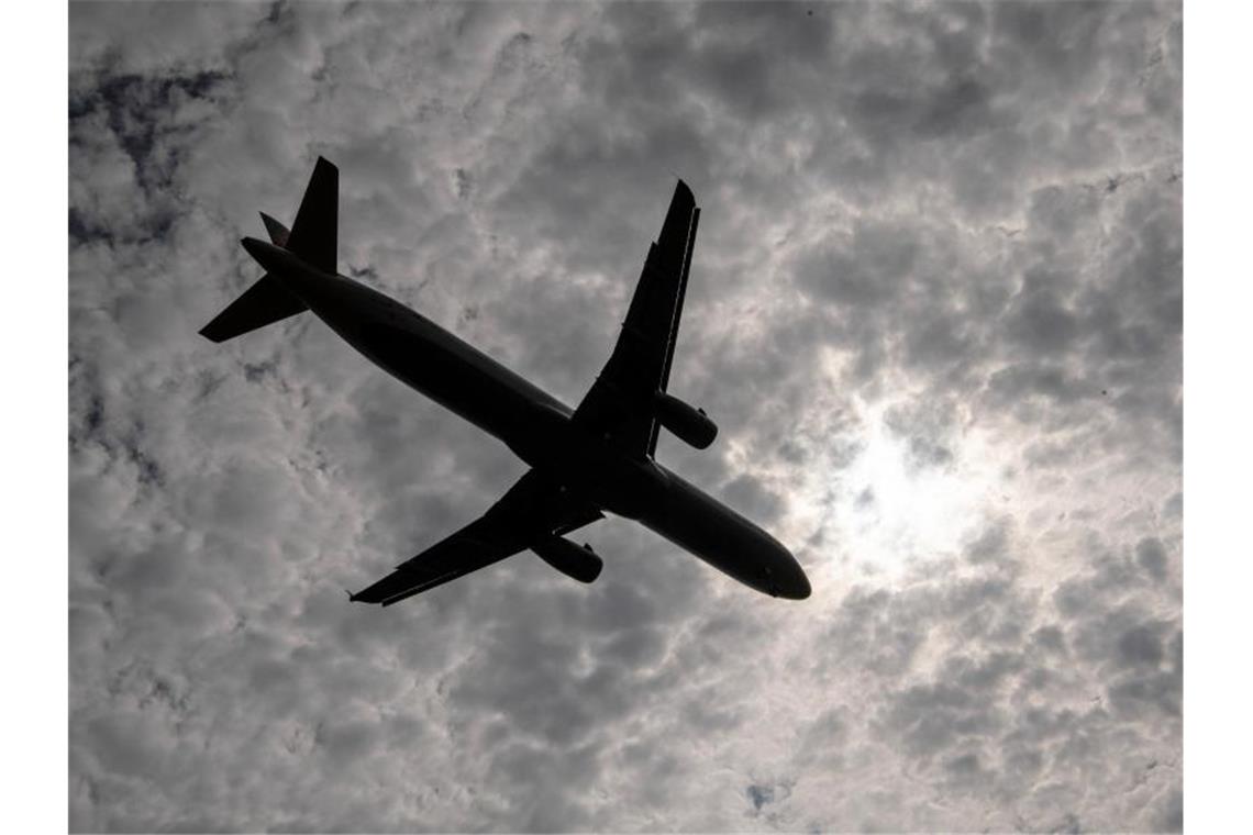 Ein Flugzeug fliegt an einem Wolkenfeld vorbei. Foto: Boris Roessler/Archivbild
