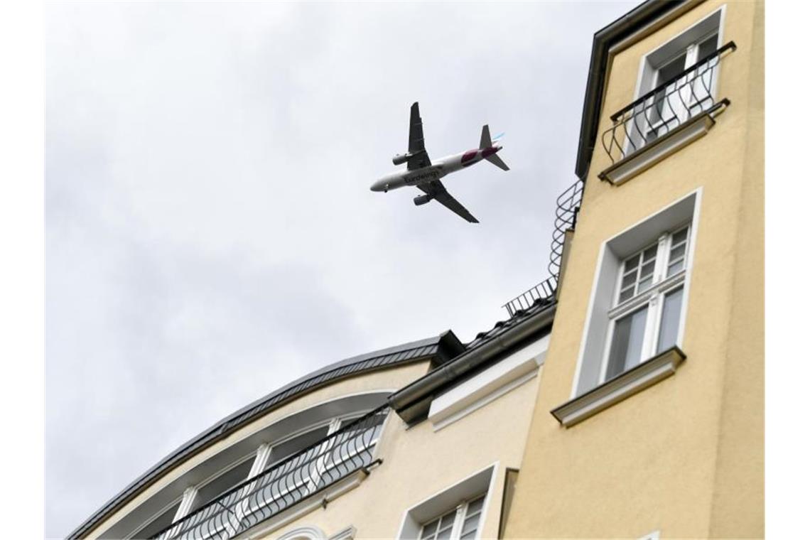 Ein Flugzeug fliegt über Wohnhäuser. Foto: Jens Kalaene/dpa-Zentralbild/ZB/Archivbild