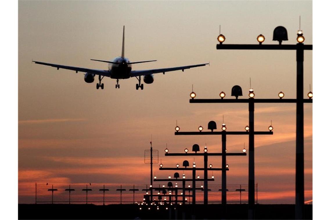 Ein Flugzeug ist während des Sonnenuntergangs im Landeanflug auf den Flughafen. Foto: Kevin Kurek/dpa