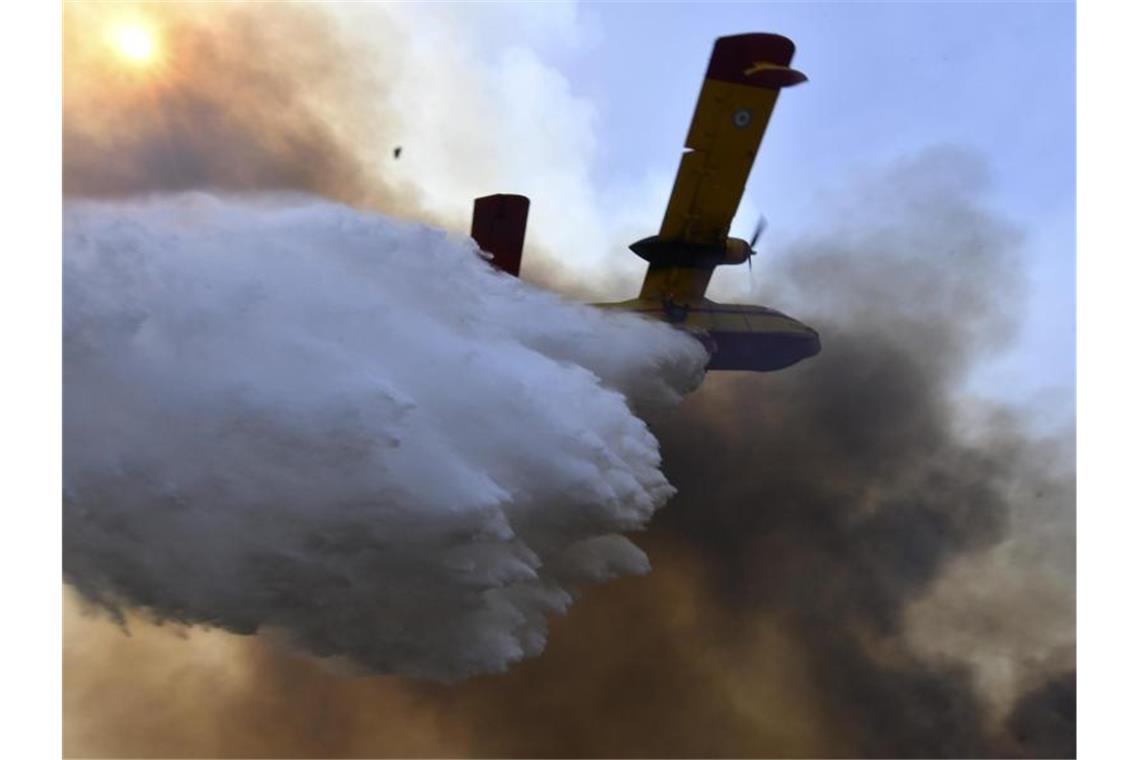 Ein Flugzeug wirft Löschwasser über einem Waldbrand in Olympia ab. Foto: Giannis Spyrounis/ilialive.gr/AP/dpa