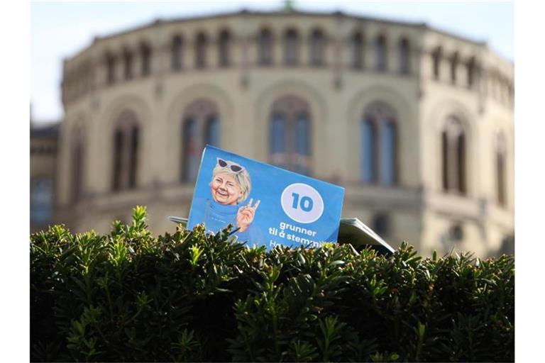 Ein Flyer der norwegischen Regiergungschefin Erna Solberg steckt vor dem Parlament in Oslo in einer Hecke. Bewahrheiten sich die Umfragen, dann ist die Regierungszeit der konservativen Ministerpräsidentin nach acht Jahren zu Ende. Foto: Steffen Trumpf/dpa