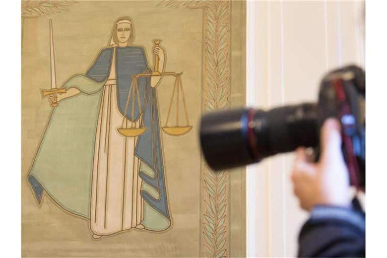 Ein Fotograf vor dem Bild der Justitia. Foto: Friso Gentsch/Archivbild